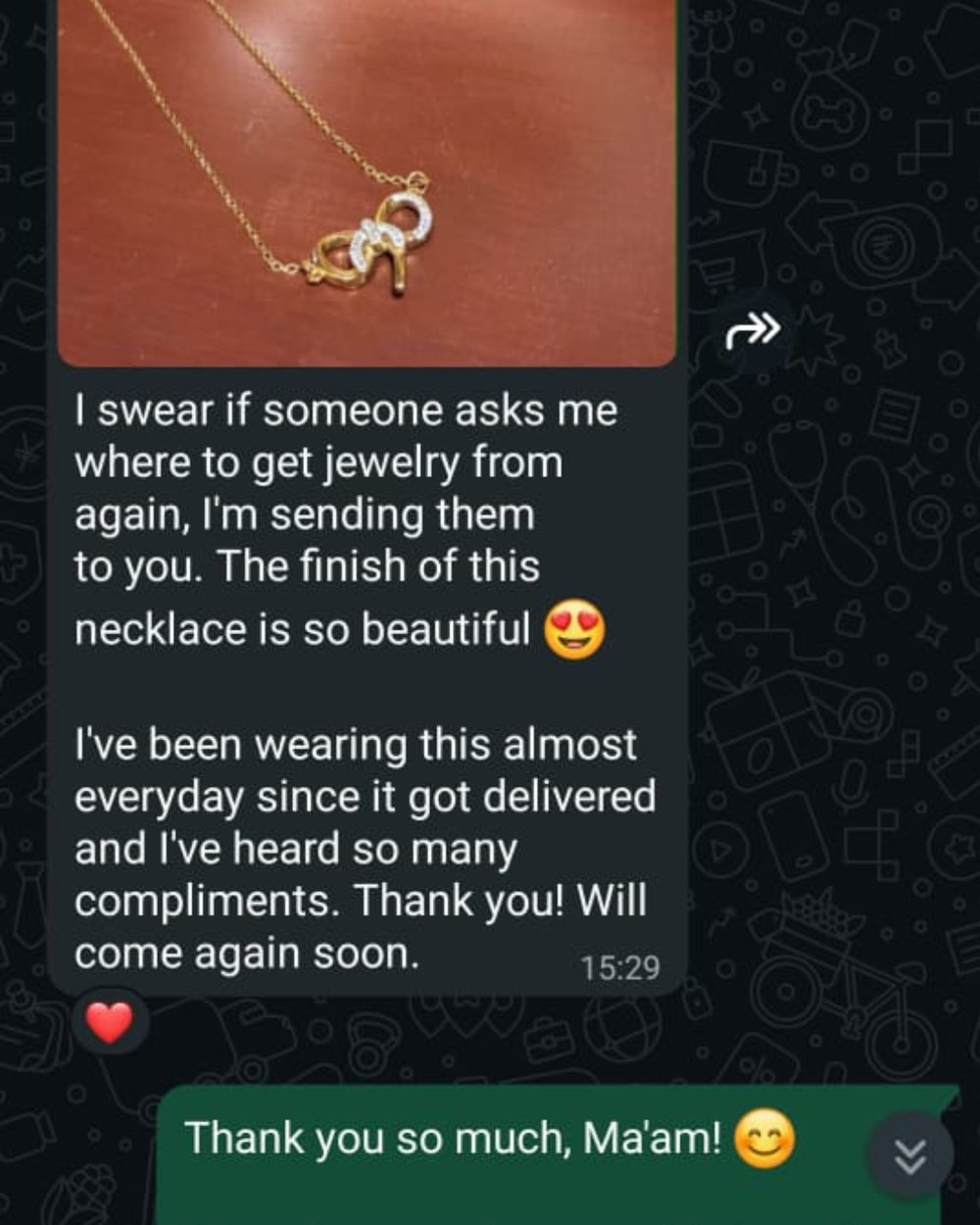 A text message screenshot featuring a photo of a gold necklace with a white crystal pendant on a brown background, accompanied by a message praising the necklace.