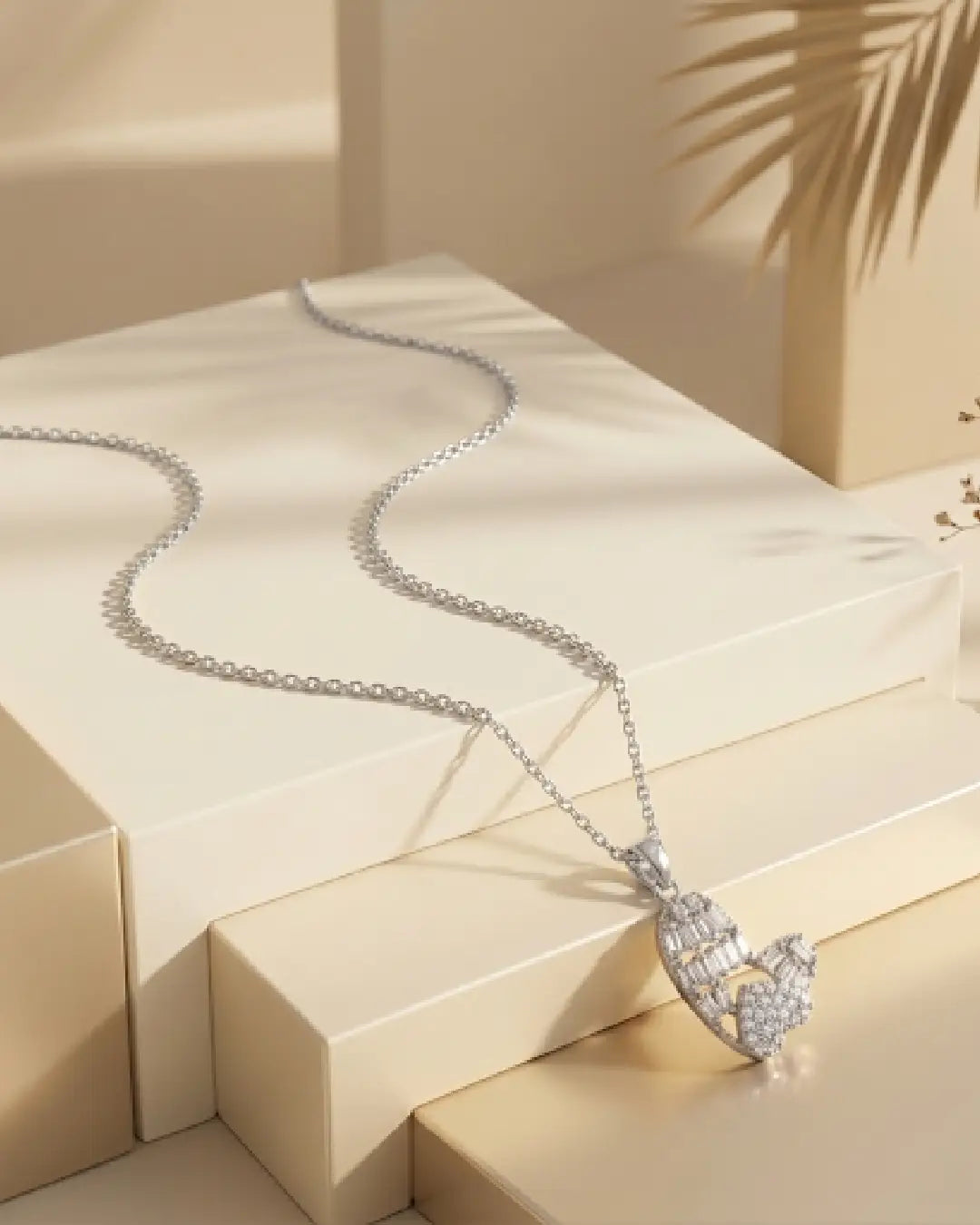 Silver tonned necklace with a heart-shaped pendant on a beige surface